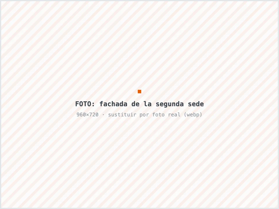 Gerente delante de la fachada de la segunda sede de su taller mecánico